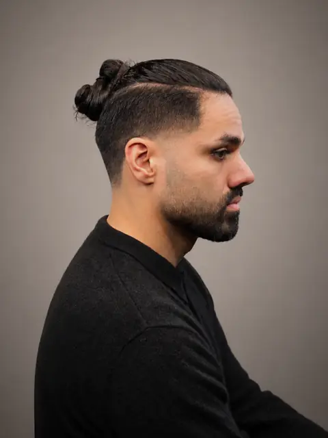 Man bun med skin fade, hard part og trimmet skæg